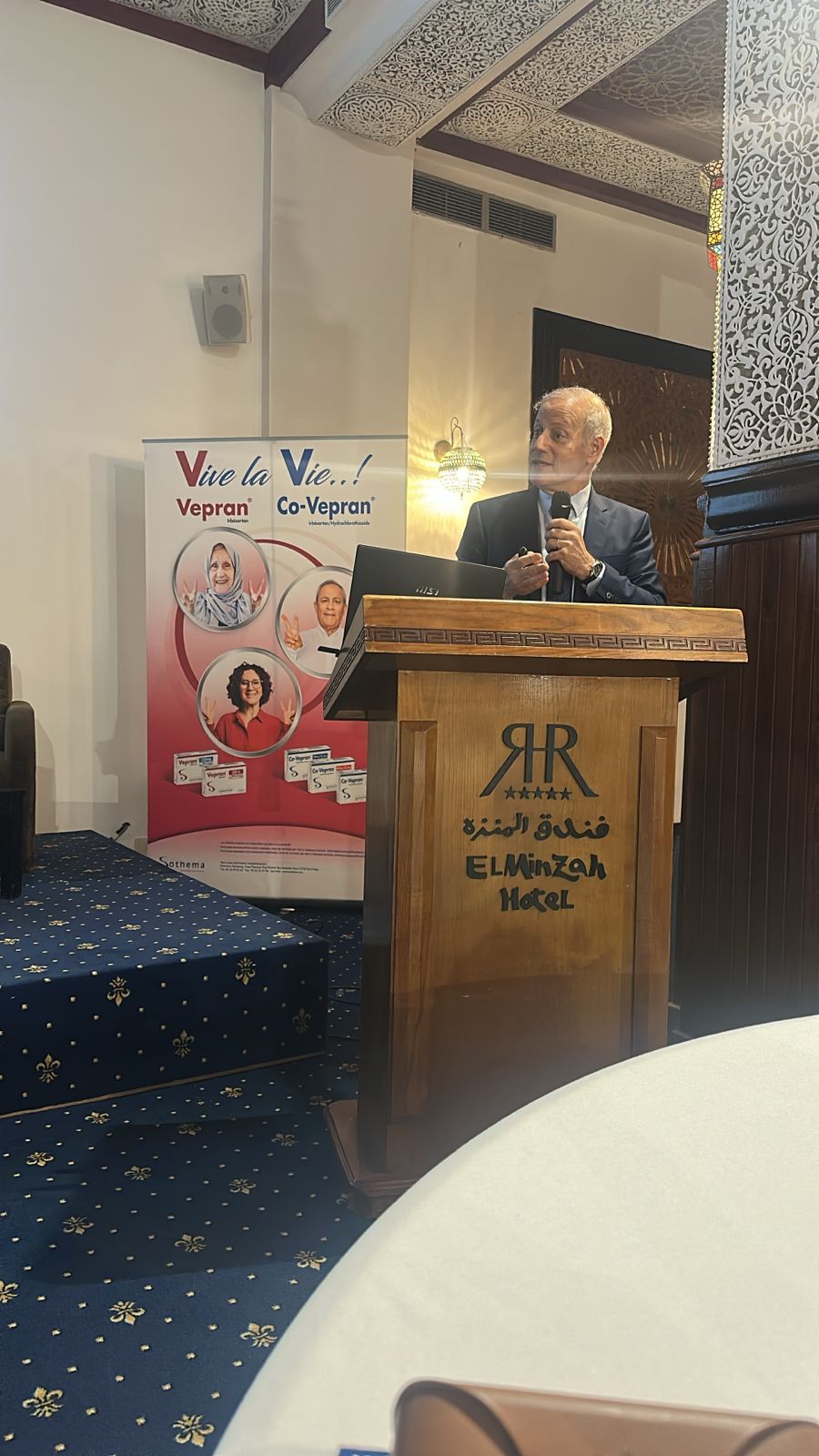 Speaker addressing the audience from the El Minzah Hotel podium